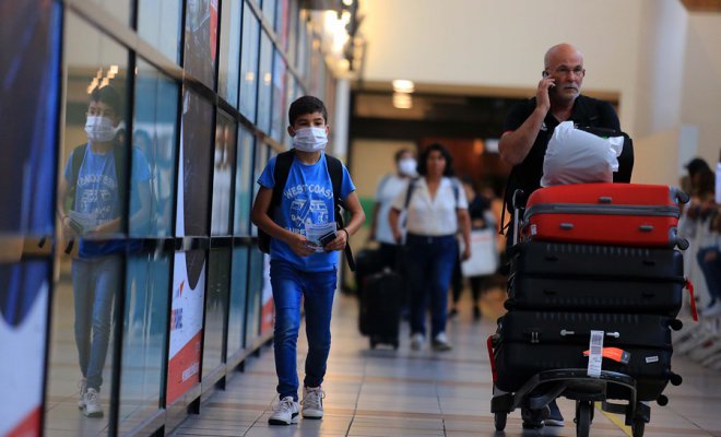 boy with a mask protection walking at the airport with his parent during quarantine