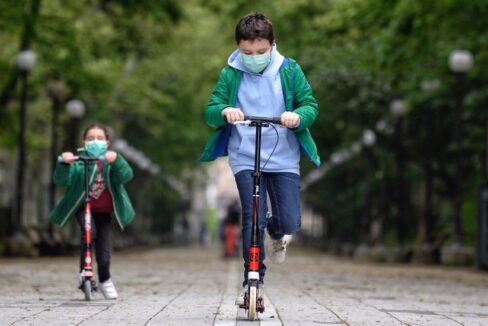 dos niños montan scooters durante el confinamiento