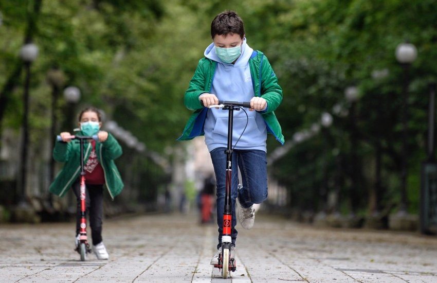 dos niños montan scooters durante el confinamiento